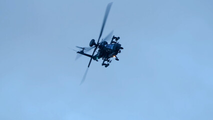 close-up of a British army Boeing Apache Attack helicopter gunship AH64E (AH-64E ArmyAir606) at full bank in a hammerhead stall turn, Wiltshire UK