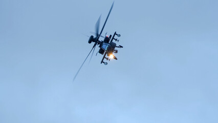 close-up of a British army Boeing Apache Attack helicopter gunship AH64E (AH-64E ArmyAir606) at full bank in a hammerhead stall turn, Wiltshire UK