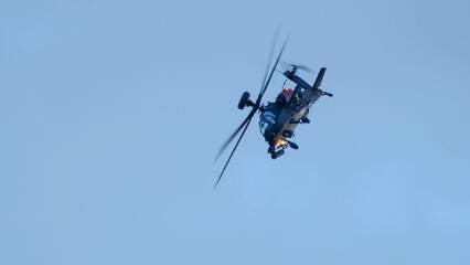 close-up of a British army Boeing Apache Attack helicopter gunship AH64E (AH-64E ArmyAir606) at full bank in a hammerhead stall turn, Wiltshire UK