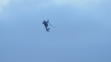 Fototapeta na wymiar British army Boeing Apache Attack helicopter gunship (AH64E AH-64E ArmyAir606) banking hard in flight, Wiltshire UK