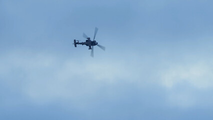 Fototapeta na wymiar British army Boeing Apache Attack helicopter gunship (AH64E AH-64E ArmyAir606) banking hard in flight, Wiltshire UK