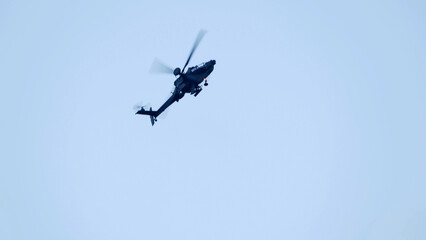 British army Boeing Apache Attack helicopter gunship AH64E (AH-64E ArmyAir606) at full bank in a hammerhead stall turn, Wiltshire UK