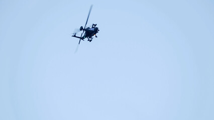 British army Boeing Apache Attack helicopter gunship AH64E (AH-64E ArmyAir606) at full bank in a hammerhead stall turn, Wiltshire UK