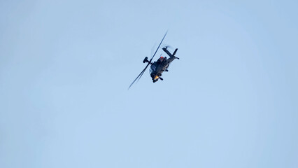 British army Boeing Apache Attack helicopter gunship AH64E (AH-64E ArmyAir606) at full bank in a hammerhead stall turn, Wiltshire UK