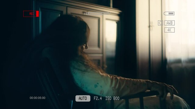 Senior woman writhing in armchair, possessed by demonic spirit, occult rituals