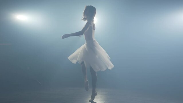 Ballerina spinning around in tutu skirt on stage
