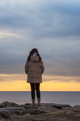 Fototapeta premium a girl's walk along the embankment of Istanbul. a woman in a warm jacket in winter Istanbul. A frozen girl walks through cold Turkey