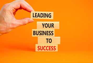 Leading your business to success symbol. Concept words Leading your business to success on wooden blocks. Beautiful orange table orange background. Leading your business to success concept. Copy space