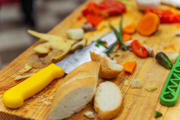 vegetable and bread scraps on a wooden board. leftovers from cooking dinner in a professional kitchen. organic waste on the chef's table