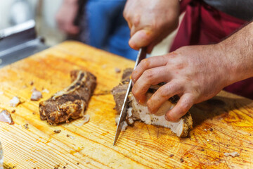 Slicing beef meat for Kazakh beshparmak. Preparation of horse meat by the chef's hands for hot dishes. Cutting large pieces of meat into small slices