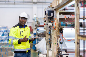 African male engineer is a mechanic Thumbs up and press like Standing near machinery and gear...