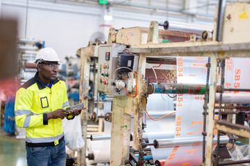 African male engineer department head Controlling machine systems and gear circuit boards and...