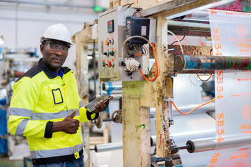 Half body portrait. African male engineer. Work at the plastic and steel industry. There are...