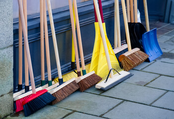 Broom brushes and snow spade for sale displayed outside of hardware shop
