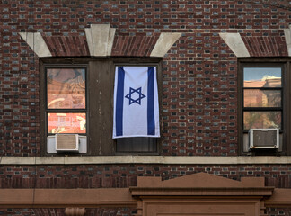 israeli flag hanging in the window of an apartment building in brooklyn, new york (support for...