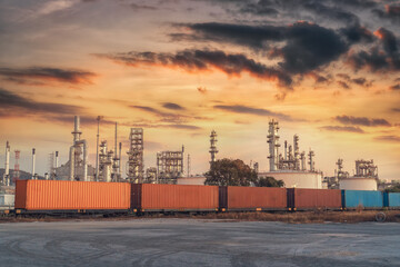 Oil refinery with a train car in the foreground and a beautiful sky in the background.