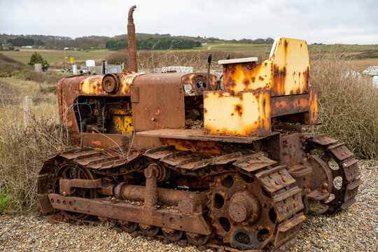 Weybourne, Norfolk, UK &ndash; December 29 2023. Rusty agricultural machinery with tracks abandoned in the countryside