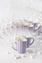 A purple mugs with hot coffee and marshmallows. Two cups with marshmallows in snowflake shapes. Kaleidoscope effect.