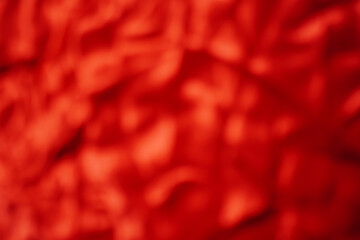 Satin or silk, red, wavy or wrinkled for background work Blurry