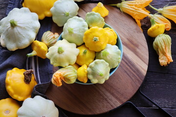 Yellow and patisson, pattypan scallop squash vegetable on blue plate on white marble table background. Top view, flat lay. Autumn, fall harvest concept