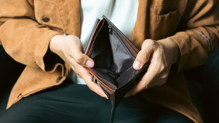 Poor man bankrupt with no credit in debt hand hold empty black leather wallet because economy down...