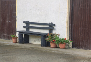 farmhouse facade with wooden bench with flowers