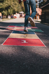 Child feet jumping on hopscotch 