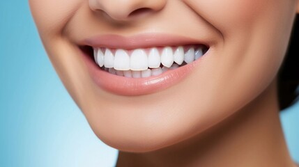 Fototapeta premium Versatile photorealistic banner with a girl smiling with beautiful teeth close up on a bright blue plain background, close up of her face with space to insert text