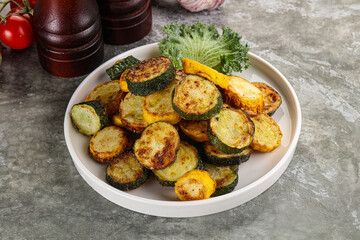 Roasted young zucchini in the plate