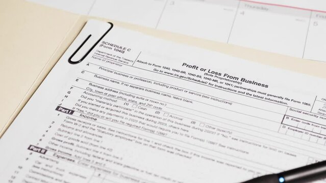 Schedule C tax form document on table
