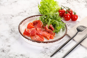 Sliced salmon with fresh arugula