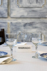 Reserved sign amidst glasses and plates on a table in a traditional restaurant.