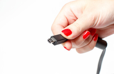 Little white computer connector in a girl's hand on a white background