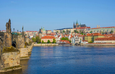 Fototapeta na wymiar Famous Charles Bridge on Vltava River with Hradcany castle and St. Vitus Cathedral in Prague, Czech Republic, in sunny day