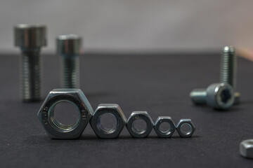 Metal bolts and nuts of different sizes on the table