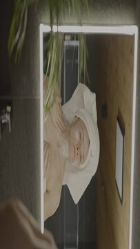Caucasian female in her 40s is making her daily skin care routine
