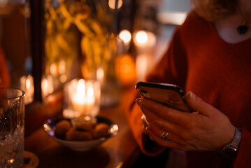 Person with smartphone in restaurant.