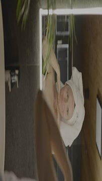 Caucasian female in her 40s is making her daily skin care routine
