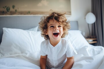 Child playing in bed in white sunny bedroom with window.