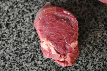 fresh piece of beef steak on a gray background, a piece of beef, a piece of veal tenderloin
