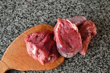 slices of red sliced beef meat, beef tenderloin, red meat on a grey background 	
