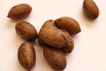 Assortment pile of closed whole pecans on background