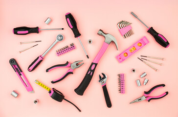 Renovation tools for a girl. Men's work is done by woman's hands. Strong, but beautiful. Pink construction equipment  on pink background. Woman's or girl's power.  Top view flat lay