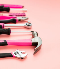 Renovation tools for a girl. Men's work is done by woman's hands. Strong, but beautiful. Pink construction equipment  on pink background. Woman's or girl's power.  Selective focus