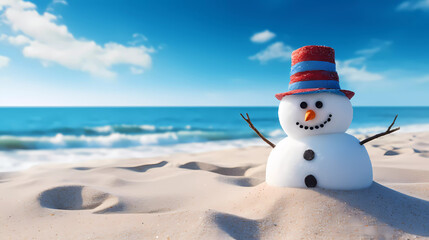 A snowman is standing in the sand on the beach with a hat on it's head and a blue sky in the background