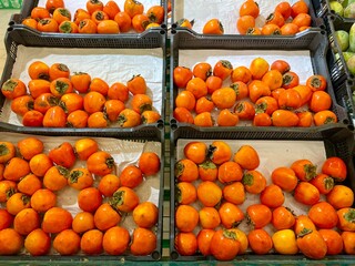 Ripe orange persimmons are on the store counter.