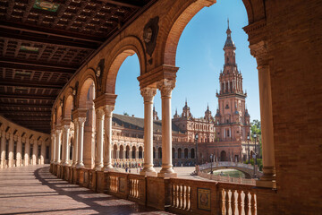 The Plaza de España galleries lited up with evening sunlight making magic shadows. North tower view on Spain Square, Andalusia, South Spain. - obrazy, fototapety, plakaty