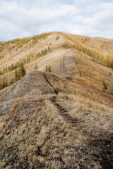 Mountain autumn landscape, hiking route runs along the mountain range, black line hiking trail for walking in the mountains.