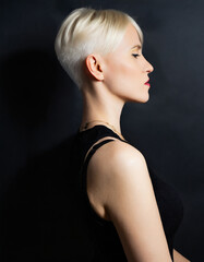 Fototapeta premium woman in blonde, short hair on dark background
