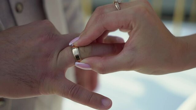 Bride and groom at wedding ceremony. Man put on a ring on a woman finger. Exchange jewelry rings, symbol of love.